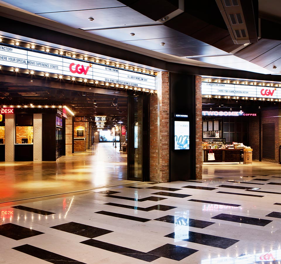 A bright and well-lit cinema lobby with a service desk and coffee stall.