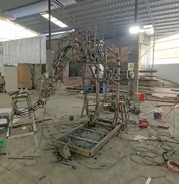 The exoskeleton of a robotic elephant in a warehouse.