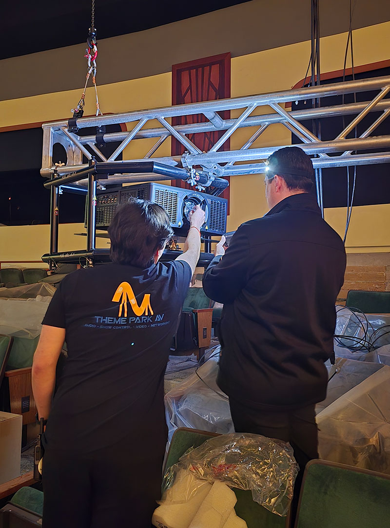 Two people rig a 1DLP projector.