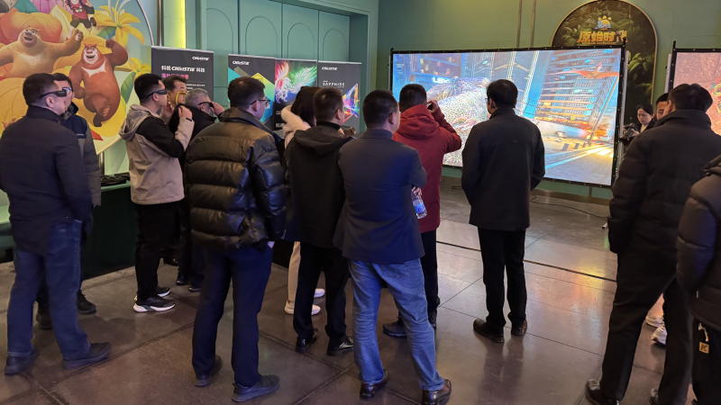 A group of people stand in front of a large screen displaying a vibrant projected image. 