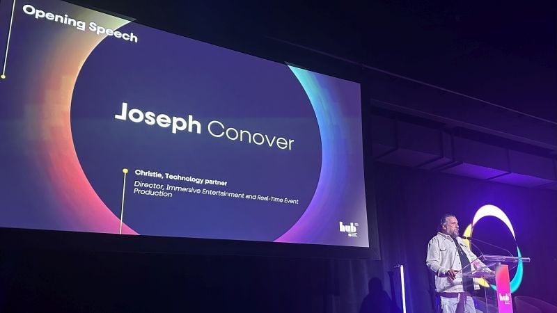 A man stands in front of a podium on a large stage.