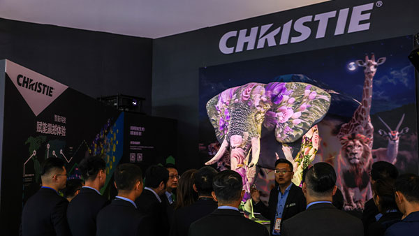 Attendees looking at a projection mapping display of an elephant in the Christie booth at InfoComm China 2025.
